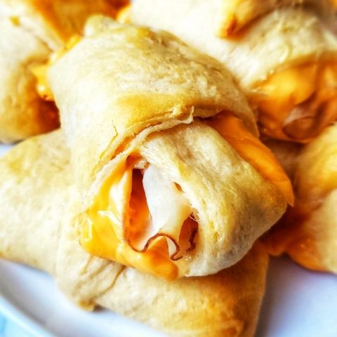 Thin slices of turkey and slices of cheese are rolled into crescent roll dough and baked for the perfect lunch or snack! These Turkey and Cheese Crescent Rolls can be made with ham slices or chicken too! 