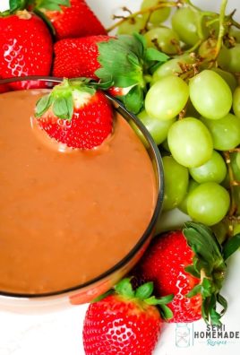 NUTELLA MARSHMALLOW DIP in a bowl surrounded by green grapes and red strawberries