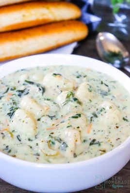 Better Than Olive Garden Chicken Gnocchi Soup in white bowl with breadsticks behind it