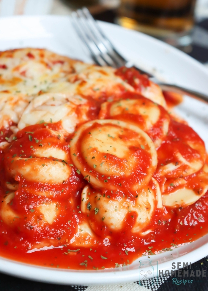baked ravioli with sauce in a white plate