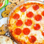 Pizza Dip - layers of cream cheese, parmesan cheese, mozzarella cheese and pizza sauce are topped with more cheese and pepperoni to make this easy pizza party dip! Perfect for serving with pretzels, naan bread, or crispy cheese wisps.
