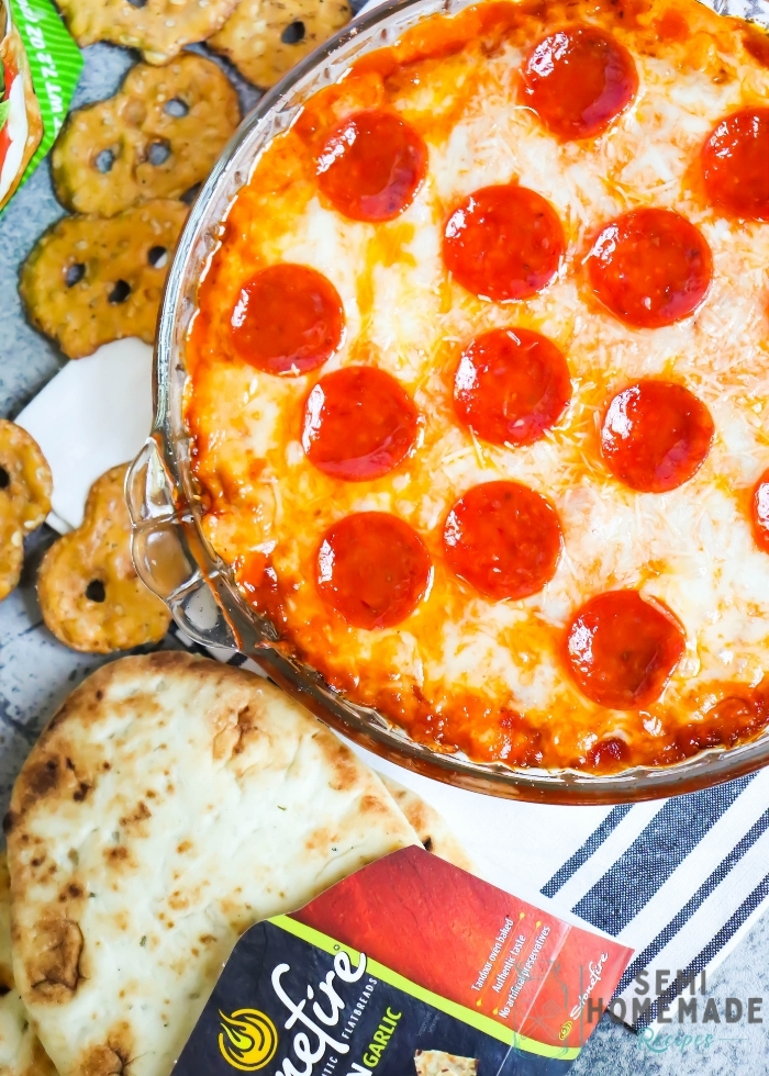 Pizza Dip – layers of cream cheese, parmesan cheese, mozzarella cheese and pizza sauce are topped with more cheese and pepperoni to make this easy pizza party dip! Perfect for serving with pretzels, naan bread, or crispy cheese wisps.
