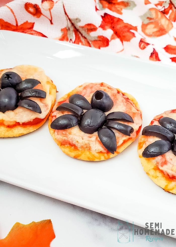 Mini Spider Pizza Bites are made with refrigerated crescent rolls, pizza sauce, shredded mozzarella cheese and black olive spiders!