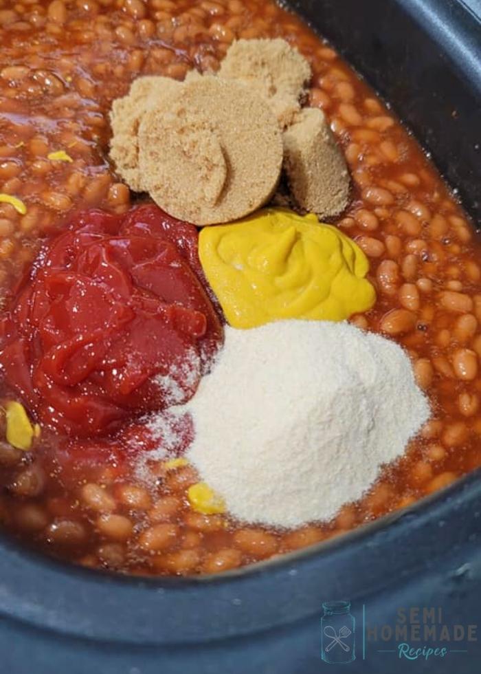 adding spices and sugars to baked beans in slow cooker