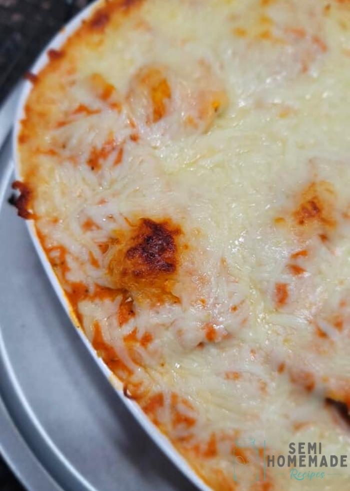 baked pasta in casserole dish with shredded cheese