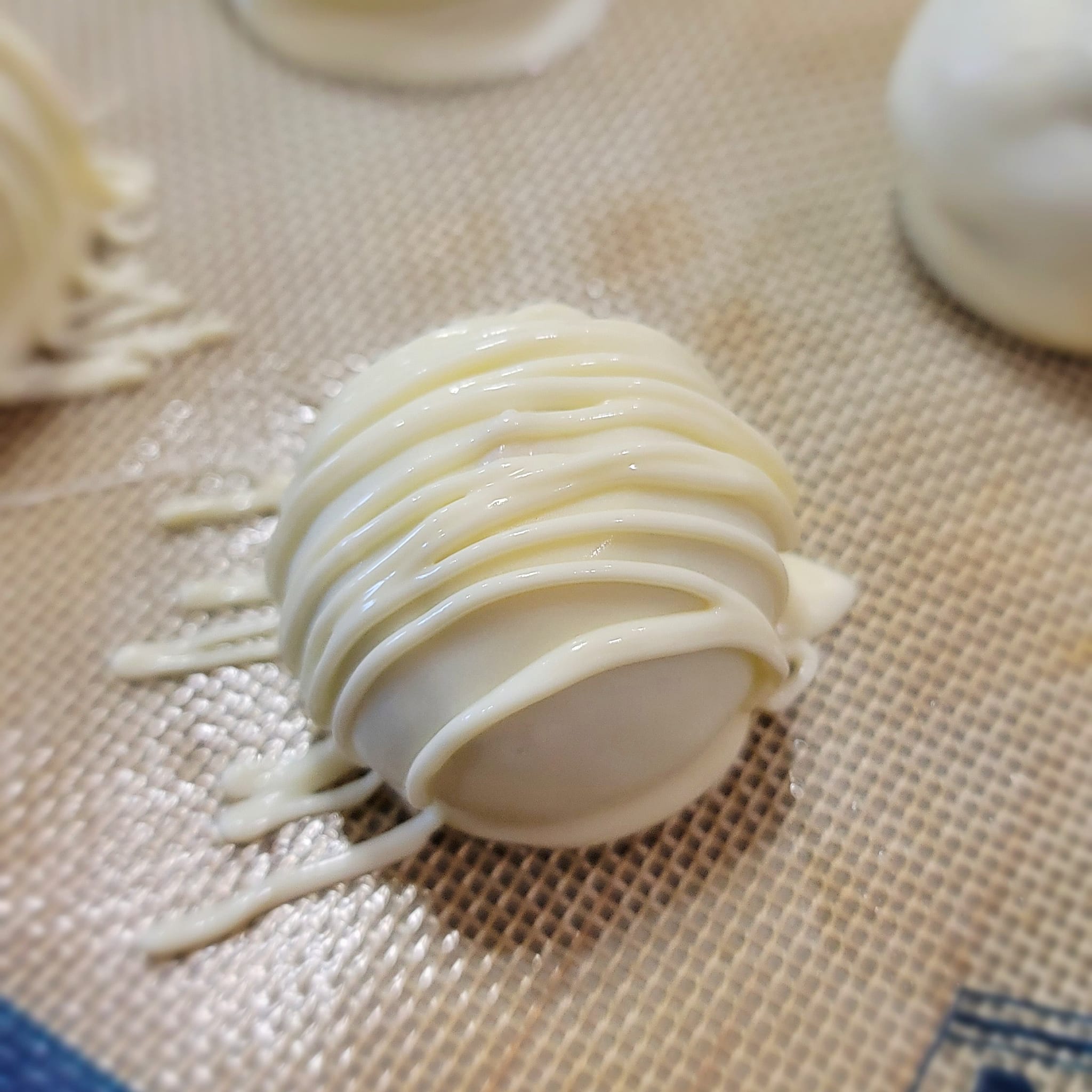 carrot cake ball covered in melting white chocolate with white chocolate drizzle