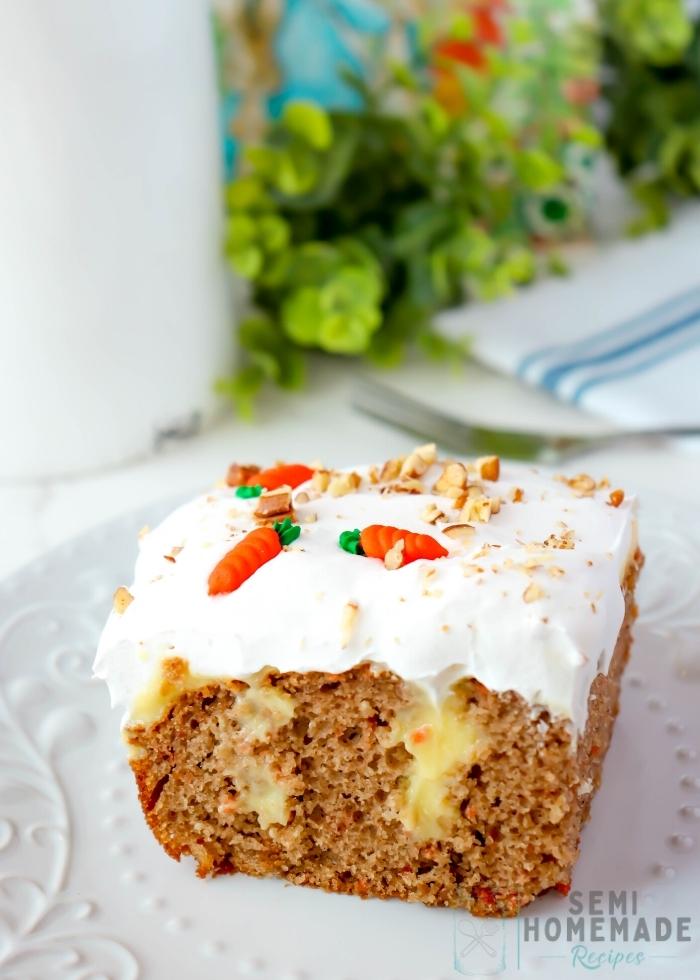 Slice of CARROT CAKE POKE CAKE on white plate with green in the background (1)