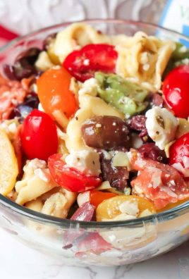Greek Pasta salad is so easy to make and the perfect make ahead side dish! Cheese tortellini is tossed together with artichoke hearts, kalamata olives, garlic, tomatoes and feta before being mixed with Greek salad dressing for a tasty and simple recipe!