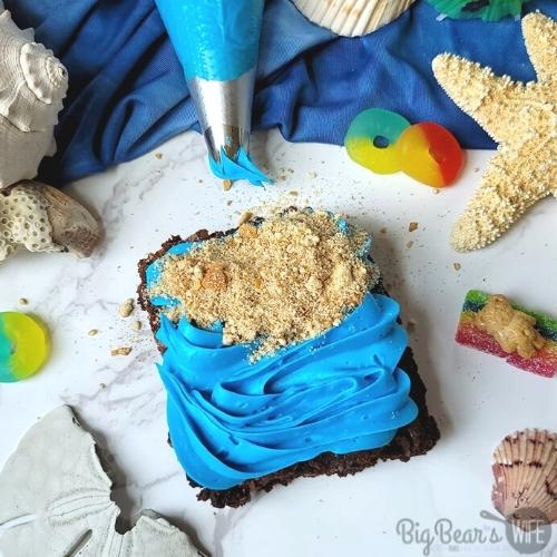 brownie with blue frosting with graham cracker frosting