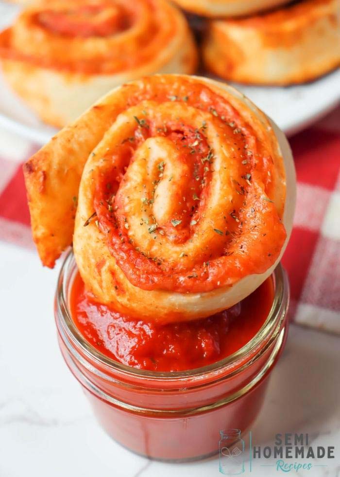 Pizza Roll sitting on top of a bowl of pizza sauce