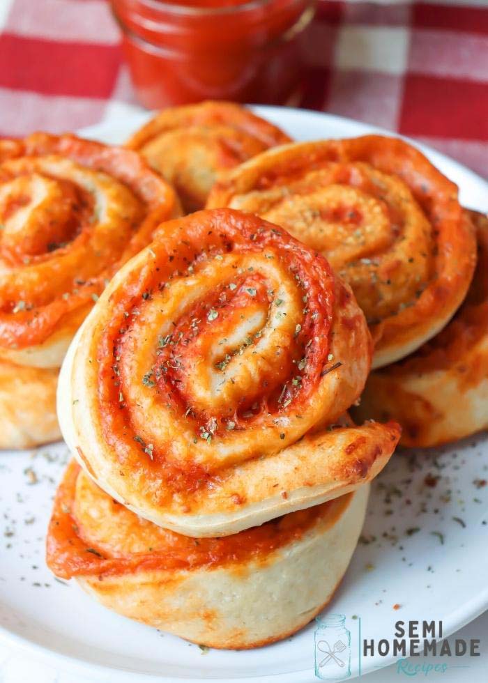 Pizza Rolls on a White Plate. - Rolls of Pizza dough, cheese and pizza sauce baked. 