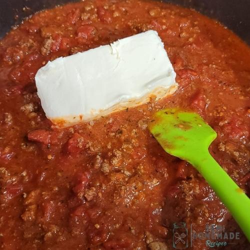 adding cheese cheese to pasta sauce