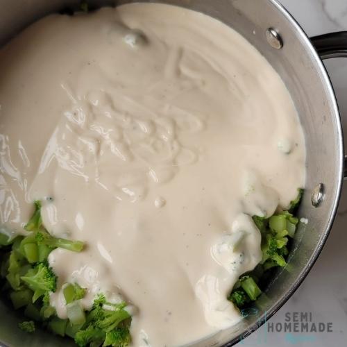 broccoli added to pot with alfredo sauce