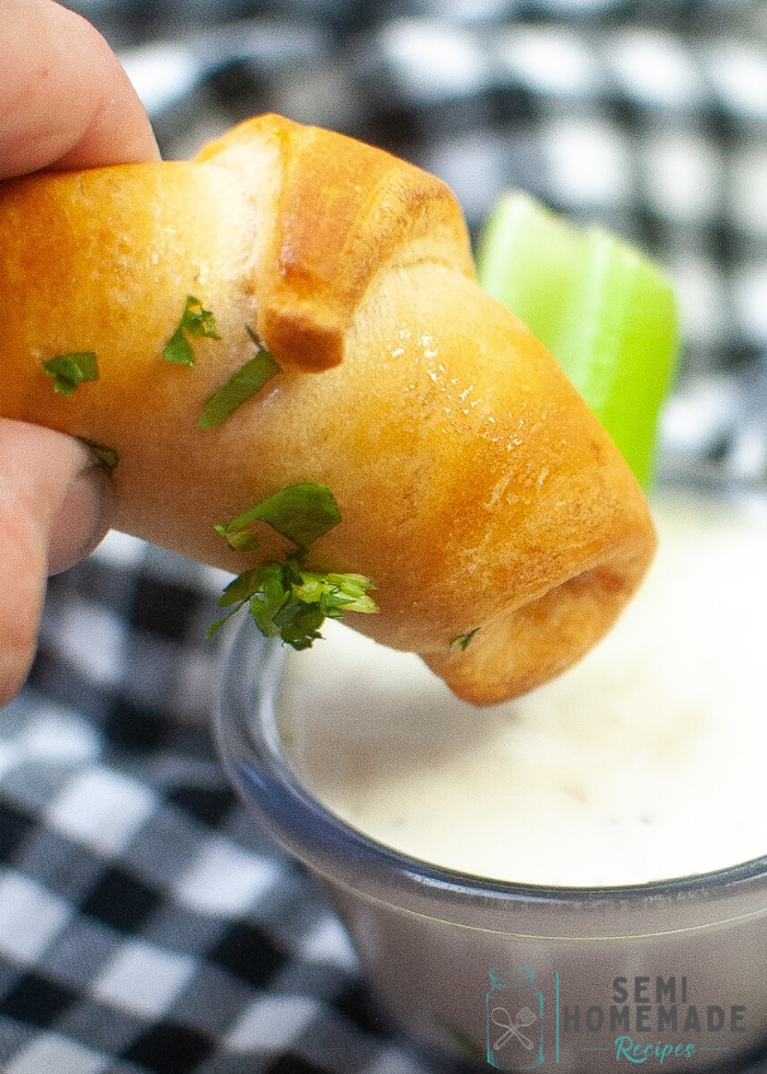 Dipping a Buffalo Chicken Crescent Roll in ranch