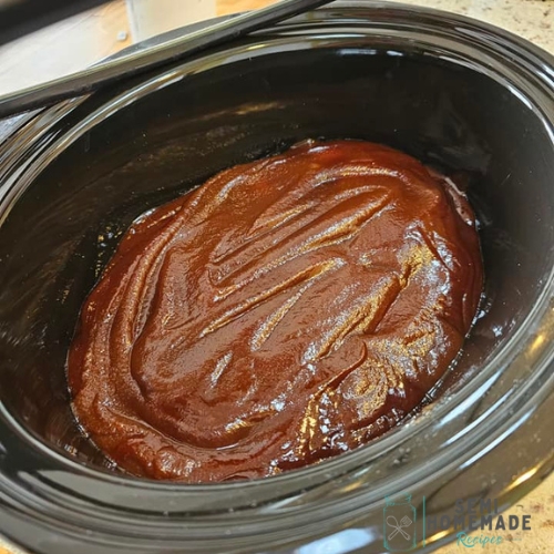 BBQ Sauce and Apple Butter poured over chicken in crock pot