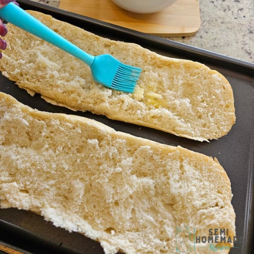 brushing melted butter on bread for pizza