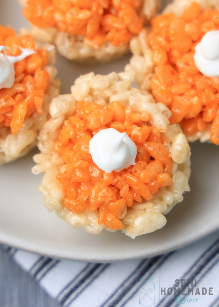 adding orange kripies to plain rice krispies in mini cupcake tin