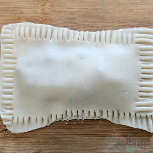 pie dough with fork crimps around edge