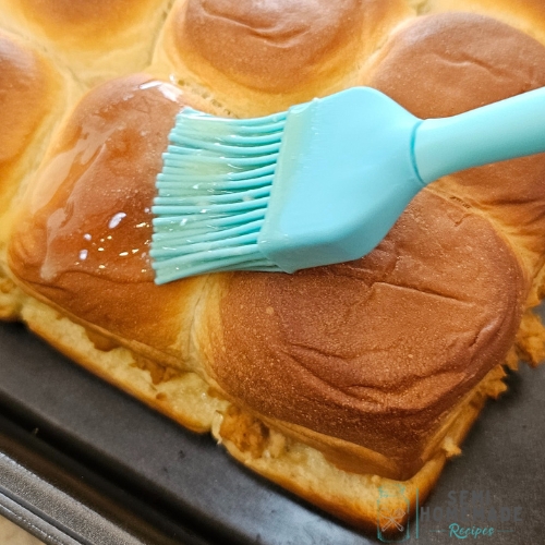 brushing butter over buns