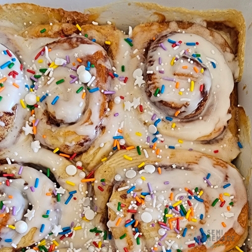 sprinkles on frosted baked cinnamon rolls
