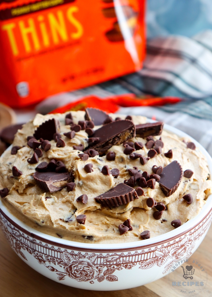 Reese&rsquo;s peanut butter cup dessert dip topped with chopped Reese&rsquo;s cups and mini chocolate chips